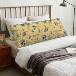 Blue floral border mustard body pillow cover styled across a bed