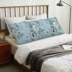 Light blue toile body pillow cover styled across a bed