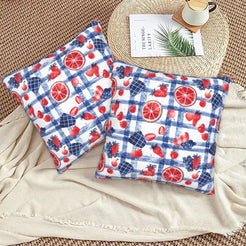 4th of July velvet pillow covers with red and blue summer picnic motifs, styled on a woven chair
