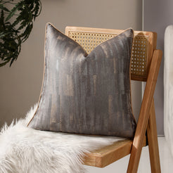 Taupe and gray abstract jacquard pillow covers styled on a chair