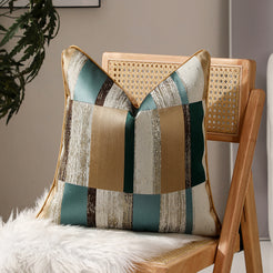 Teal, beige and brown patchwork jacquard pillow covers styled on a chair