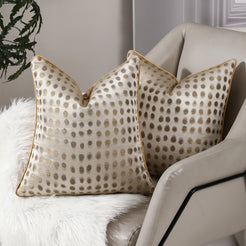 Cream and gold dot jacquard pillow covers styled on an armchair
