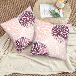 Blush and plum dahlia pattern velvet pillow covers styled on a woven chair