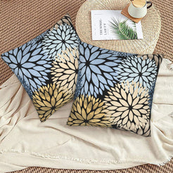 Black, light blue and cream dahlia pattern velvet pillow covers styled on a woven chair