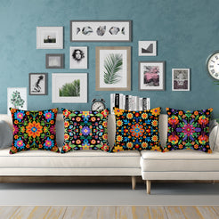 Short-pile plush pillow covers with bright folk floral patterns on black, styled on a cream sectional