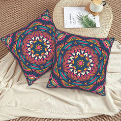 Navy orange and pink star mandala design velvet pillow covers styled on a woven chair