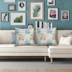 Water-resistant linen-look polyester pillow covers with hydrangeas and bows on horizontal stripes, styled on a white sofa