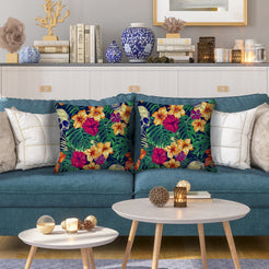 Water-resistant pillow covers with hibiscus and tropical leaves on navy, styled on a blue sofa