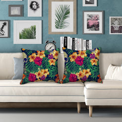 Water-resistant pillow covers with hibiscus and tropical leaves on navy, styled on a white sofa