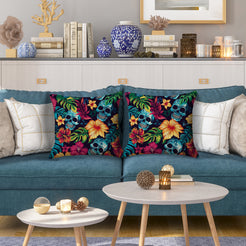 Water-resistant pillow covers with blue skulls, hibiscus and green leaves, styled on a blue sofa