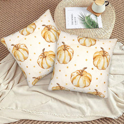 Autumn velvet pillow covers with cream repeating gold pumpkins, styled on a woven chair