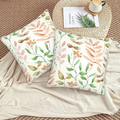Autumn velvet pillow covers with cream pastel leafy branches, styled on a woven chair