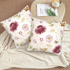 Autumn velvet pillow covers with cream burgundy flowers, styled on a woven chair