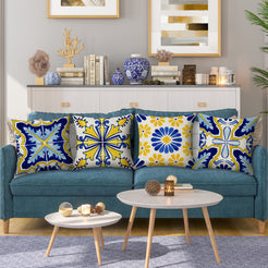 Water-resistant linen-look polyester pillow covers with blue and yellow floral tile patterns, styled on a teal sofa