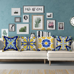 Water-resistant linen-look polyester pillow covers with blue and yellow floral tile patterns, styled on a cream sectional