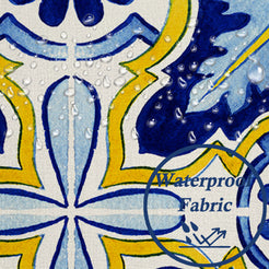 Close-up of water beads on fabric on water-resistant linen-look polyester pillow cover with blue and yellow floral tiles