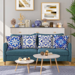 Water-resistant linen-look polyester pillow covers with blue and white floral tile patterns, styled on a teal sofa