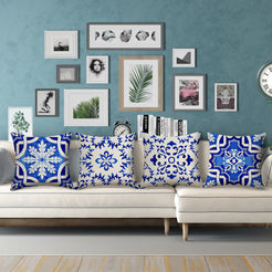 Water-resistant linen-look polyester pillow covers with blue and white floral tile patterns, styled on a cream sectional