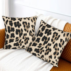 Velvet pillow covers with cream oversized leopard spots, styled on a white sofa