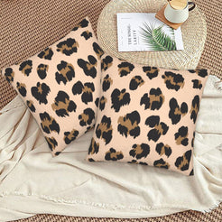 Velvet pillow covers with blush scattered leopard spots, styled on a beige sofa
