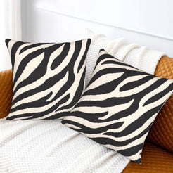 Velvet pillow covers with black and white wide zebra stripes, styled on a white sofa