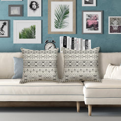 Outdoor water-resistant linen-look polyester pillow covers with black diamond medallions on gray, styled on a white sofa