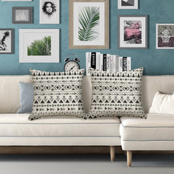 Outdoor water-resistant linen-look polyester pillow covers with black diamond lattice on cream, styled on a white sofa