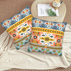 Bohemian velvet pillow covers with turquoise, orange and yellow Aztec bands, styled on a floor cushion