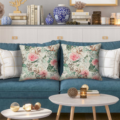 Outdoor water-resistant linen-look polyester pillow covers with pale pink roses, styled on a blue sofa