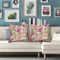 Outdoor water-resistant linen-look polyester pillow covers with bright pink roses, styled on a white sofa