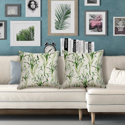 Outdoor water-resistant linen-look polyester pillow covers with green tropical leaves, styled on a white sofa