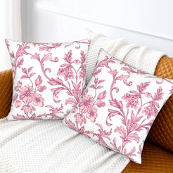 Pink toile velvet pillow covers with pink scrolling floral vines on white, styled on a sofa