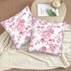 Pink toile velvet pillow covers with pink rose branches on white, styled on a woven chair