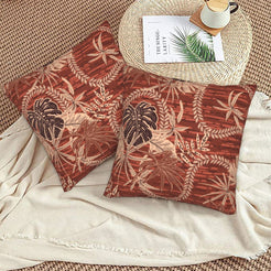 Bohemian floral velvet pillow covers with rust tropical leaves, styled on a woven chair