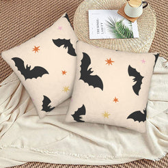 Halloween pillow covers with cream black bats, styled on a woven chair