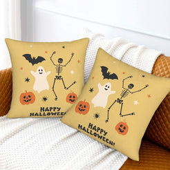 Halloween pillow covers with mustard ghosts, skeletons and pumpkins with a Happy Halloween message, styled on a sofa
