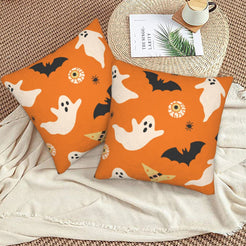 Halloween pillow covers with orange ghosts and bats, styled on a woven chair