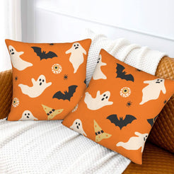 Halloween pillow covers with orange ghosts and bats, styled on a sofa