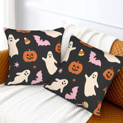 Halloween pillow covers with black ghosts, pumpkins and bats, styled on a sofa