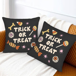 Halloween pillow covers with black candy pattern with a Trick or Treat message, styled on a sofa