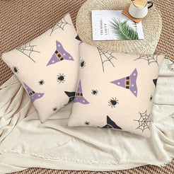 Halloween pillow covers with cream witch hats and spiderwebs, styled on a woven chair