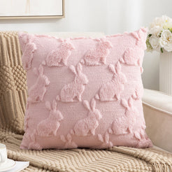 quilted polyester pillow cover with raised pink bunny silhouettes, styled on a cream chair