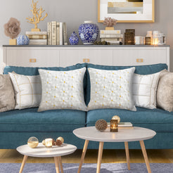 Quilted polyester pillow covers with raised white daisies, styled on a teal sofa