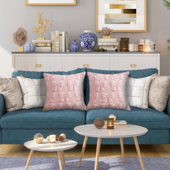 Quilted polyester pillow covers with raised pink bows, styled on a teal sofa