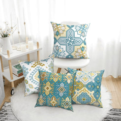 Bohemian short-pile plush pillow covers with aqua and yellow Aztec motifs, styled on a floor cushion