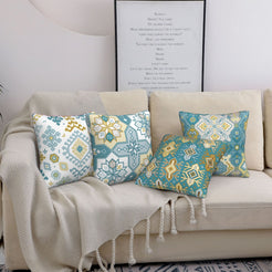 Bohemian short-pile plush pillow covers with aqua and yellow Aztec motifs, styled on a bed