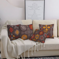 Bohemian short-pile plush pillow covers with charcoal and orange Aztec motifs, styled on a bed