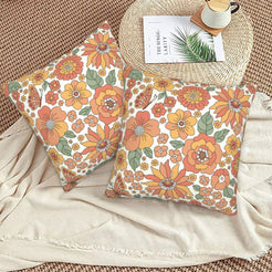 Set of two velvet pillow covers with cream dense retro autumn floral pattern, styled on a woven chair