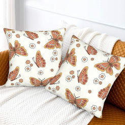 Set of two velvet pillow covers with cream butterflies and small flowers, styled on a sofa