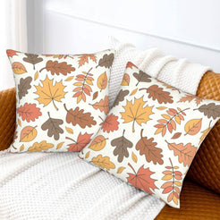 Set of two velvet pillow covers with cream autumn leaves and branches, styled on a sofa